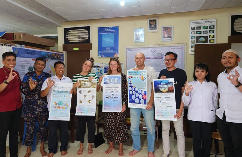 Gruppenfoto von der Hafenbehörde. Neun Personen halten Plakate mit marinen Leben in der Hand.