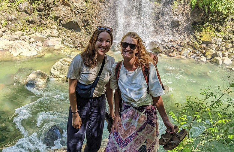 Alina und ihre Projektpartnerin vor einem Wasserfall.