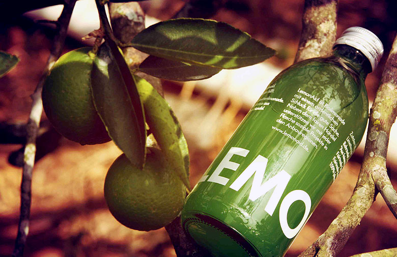 Eine grüne Lemonaid Flasche liegt in einem Lemonenbaum. Foto: Felix Gessert.