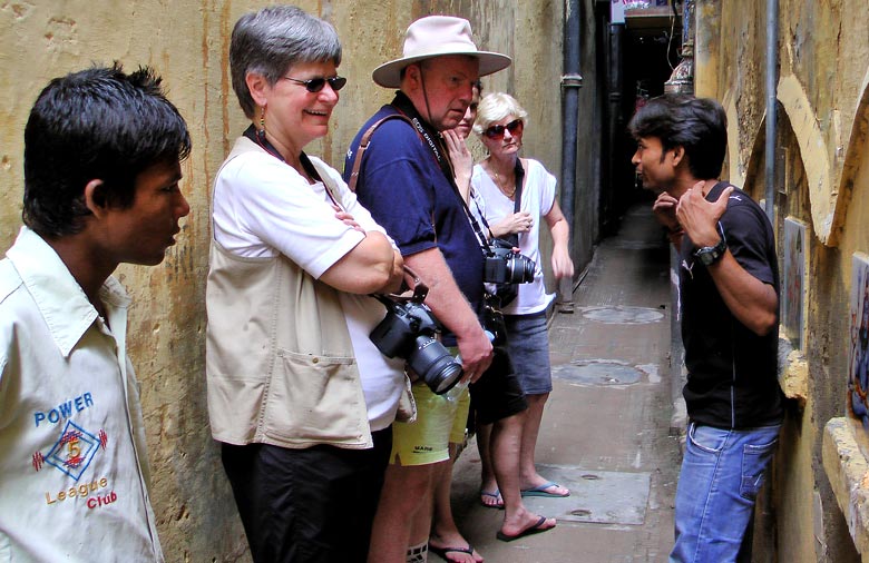 In einer engen Gasse stehen drei Touristen, ihnen gegenüber steht der Guide, der ihnen gerade etwas erklärt. Am linken Bildrand steht ein weiterer Mann. Foto: Jens Marquardt