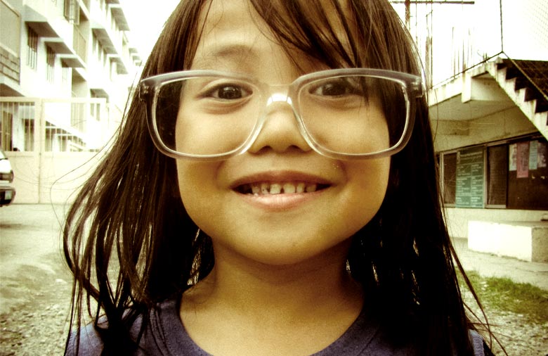 Ein Mädchen mit langen dunklen Haaren trägt eine Brille, die ihr zu groß ist. Foto: Thomas Moritz