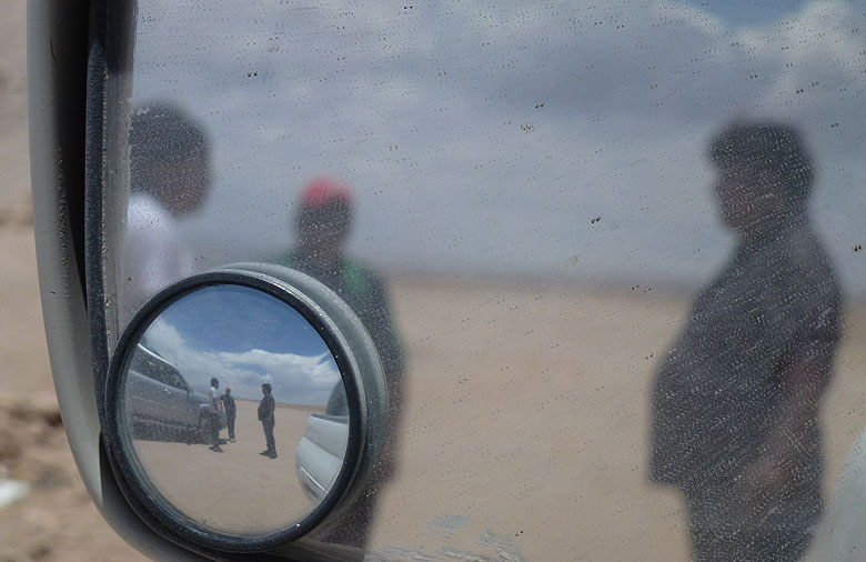 Es ist ein Seitenspiegel eines Autos in Nahaufnahme zu sehen. Er reflektiert drei Menschen in zwei verschiedenen Perspektiven, da der Spiegel über eine Vergrößerung Funktion verfügt. Foto: Kathrin Holstein