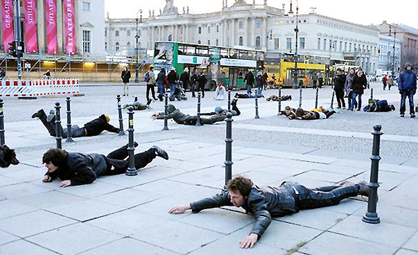 Mehrere Menschen liegen auf dem Boden auf dem Bürgersteig und machen Schwimmbewegungen. Foto: Philipp v. Zwehl