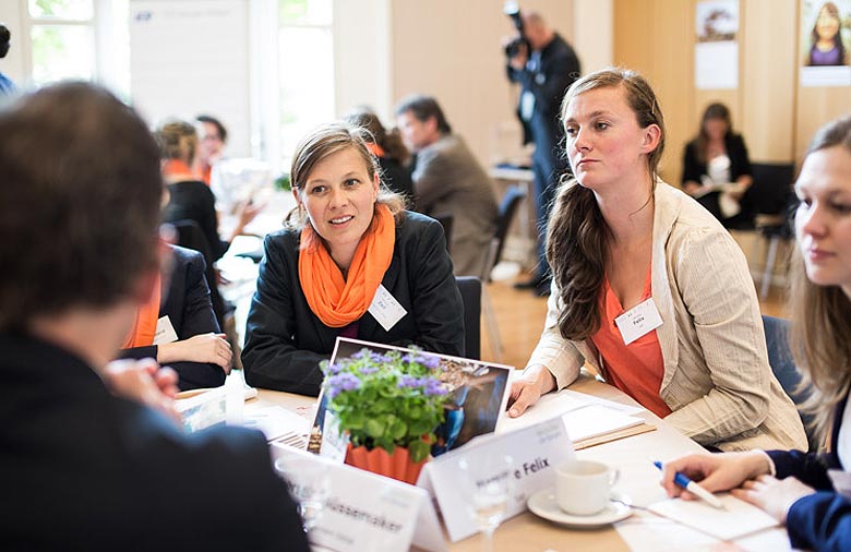 Simone Zeil, Mareike Felix und weitere Teilnehmende sitzen an einem Tisch und diskutieren. Foto: Christian Klant.