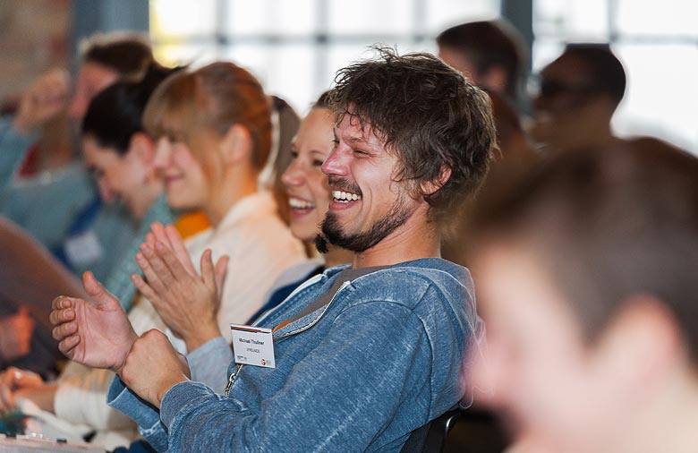 Lachende Teilnehmende sitzen im Publikum. Foto: Jule Roehr.