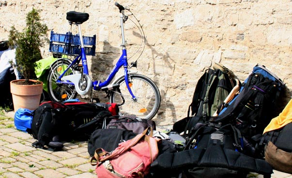 Luggage and a bicycle lean against a wall. Photo: Friedemann Wagner